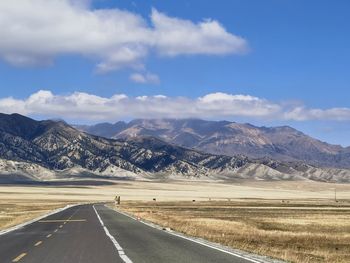 Road amidst snowcapped mountains against sky