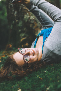 Portrait of teenage girl eyeglasses while lying on grass