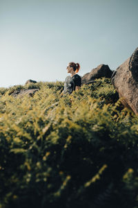 Full length of man standing on rock against sky
