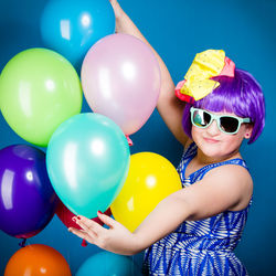 Portrait of woman holding colorful balloons