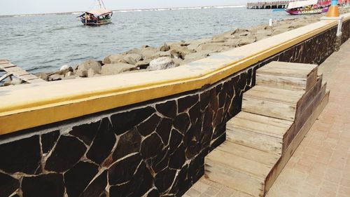 Boat moored on pier by sea