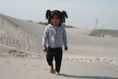 Full length of girl walking on sand at beach