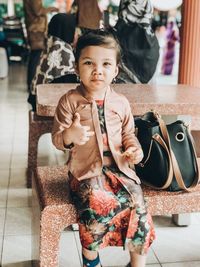 Portrait of cute girl sitting on seat