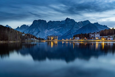 Scenic view of lake by snowcapped mountains against sky