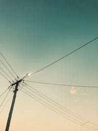 Low angle view of power cables against clear sky