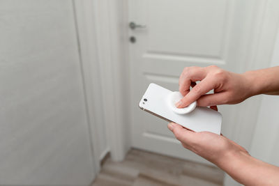 Midsection of woman holding white door