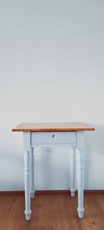 Empty wooden table against wall at home