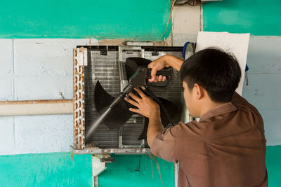 Rear view of young man working in workshop