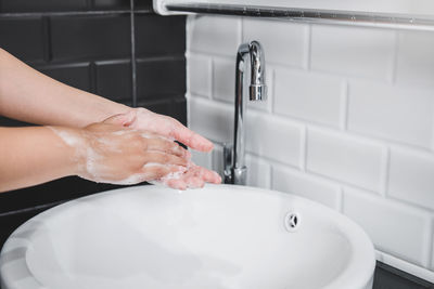 Midsection of woman in bathroom at home