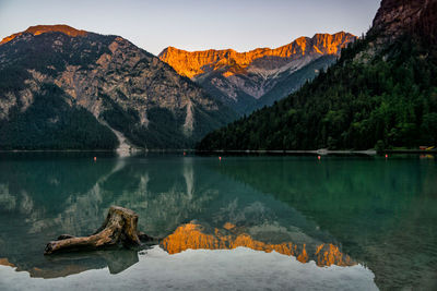 Scenic view of lake by mountains against sky