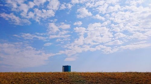 Scenic view of field against cloudy sky