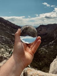 Midsection of person holding crystal ball