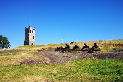 Built structure on grass against clear blue sky