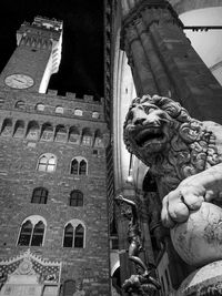 Low angle view of statue in city at night