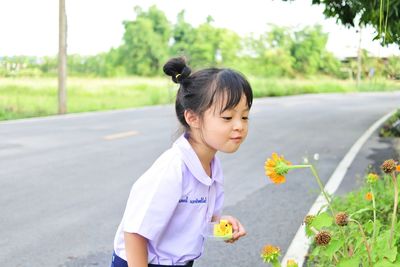 Happy girl on road by flower trees