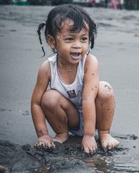 Full length of cute girl sitting on beach