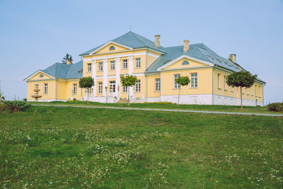 House on field against clear sky