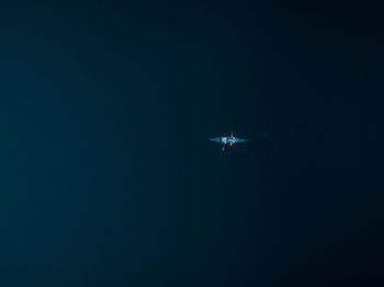 Airplane flying against clear sky at night