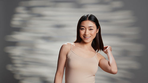 Portrait of young woman standing against sky