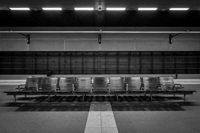 Empty chairs at illuminated subway platform