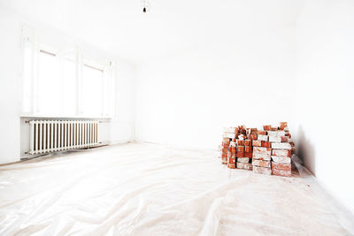 Bricks arranged by wall against radiator at home