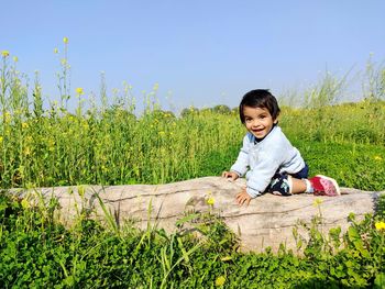 Portrait of baby boy on tree trunk