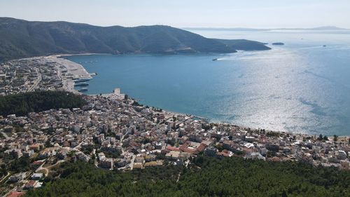 High angle view of townscape by sea against sky