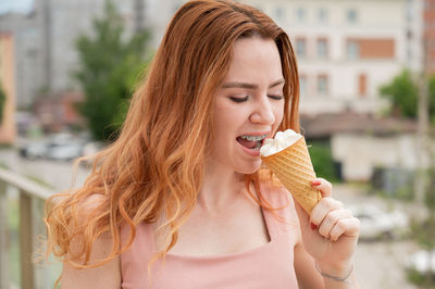 Portrait of smiling young woman holding ice cream cone