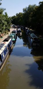 Boats moored in canal against sky