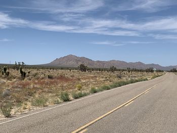 Road amidst desert against sky