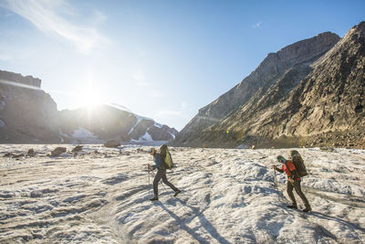 People on snowcapped mountain against sky