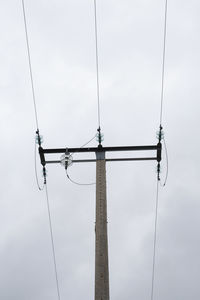 Low angle view of electricity pylon against sky