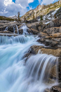 Scenic view of waterfall against sky