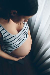 High angle view of pregnant woman standing at home