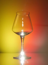 Close-up of wineglass against yellow background