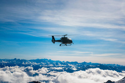 Airplane flying over snowcapped mountains against sky