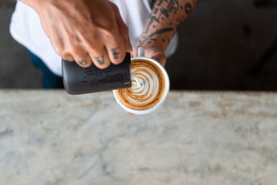 Midsection of man holding coffee cup