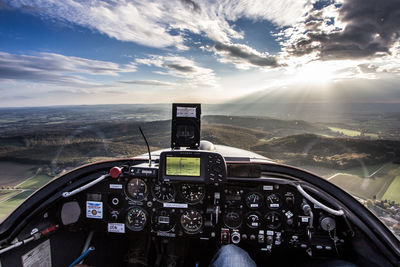 Midsection of pilot flying airplane over mountains