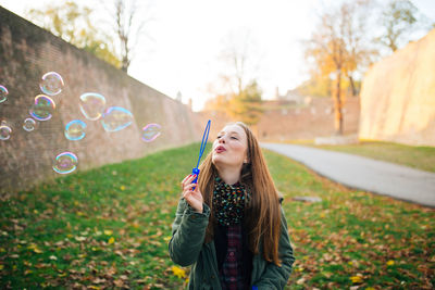 Happy young woman standing at park