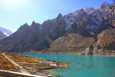 Scenic view of lake by mountains against sky