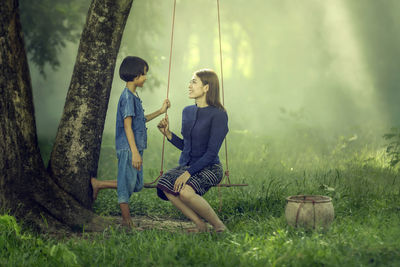 Full length of happy young woman in grass