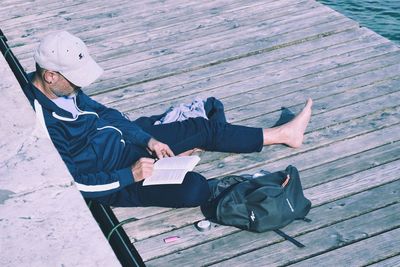 Rear view of man sitting on deck chair