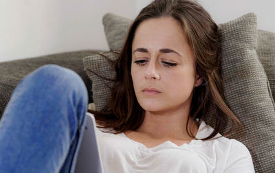 Portrait of young woman sitting on sofa at home