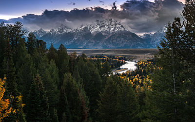 View of trees and mountains against cloudy sky