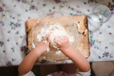 Closeup of the hands of a little girl while playing with pasta and flour in the kitchen