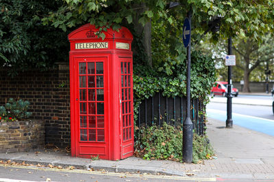 Red telephone booth on footpath
