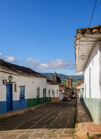 Houses by street in town against sky