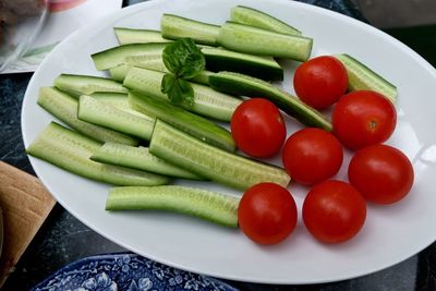 High angle view of cucumbers and tomatoes in plate on table