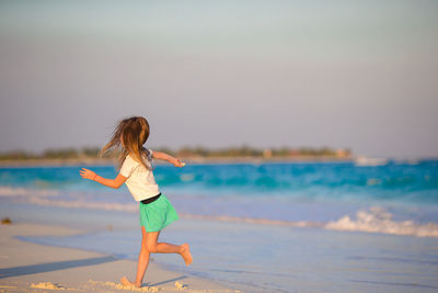 Full length of woman on beach against sky