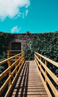 View of footbridge against blue sky